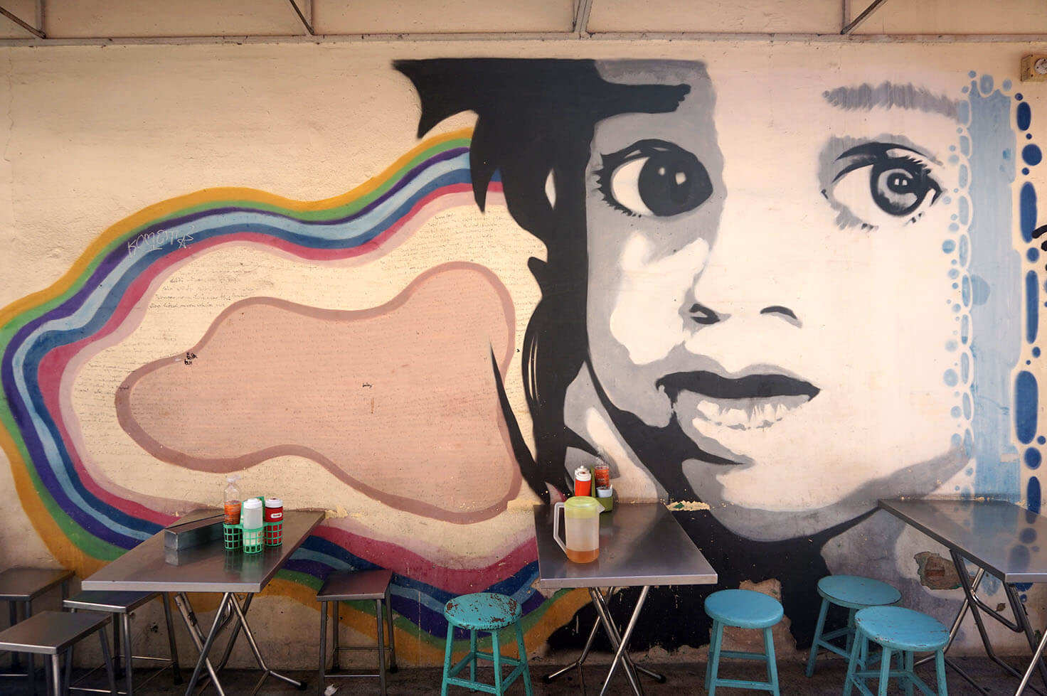Child with a rainbow cloud graffiti in Bangkok